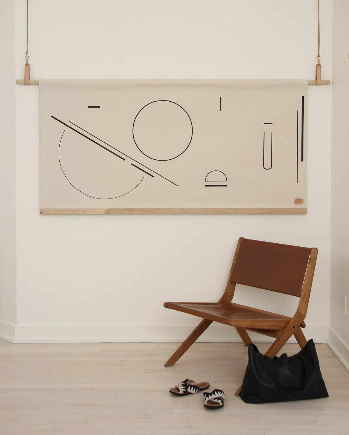 a modern interior with an abstract black line drawing on a large wall hanging