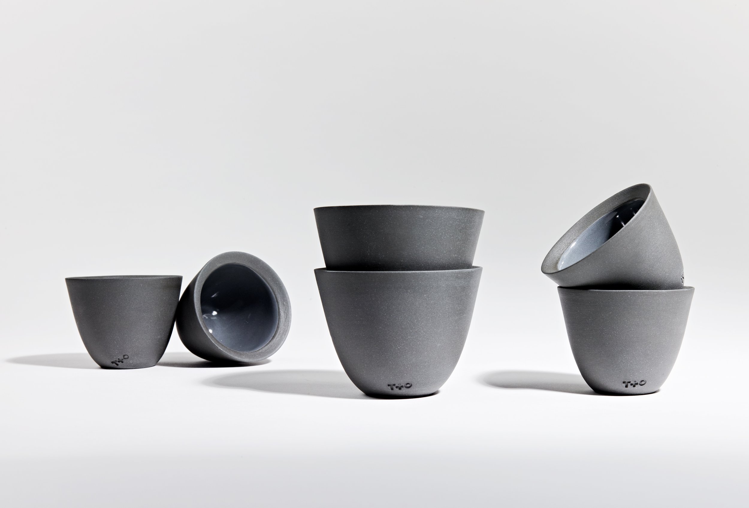 stacked grey ceramic cups with black interiors by thoughts and objects