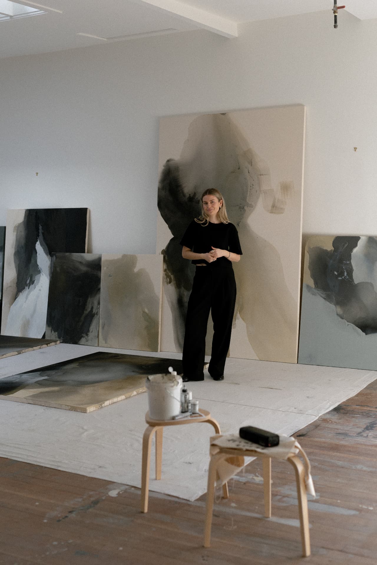 joy kinna standing before a large abstract canvas in her studio